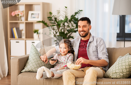 Image of happy father and daughter watching tv at home