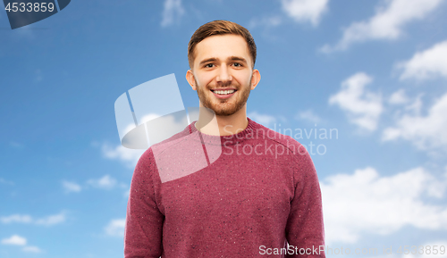 Image of smiling young man over blue sky background