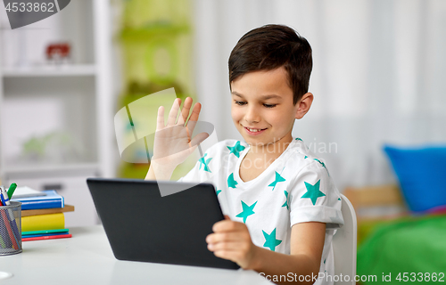 Image of boy with tablet computer having video chat at home