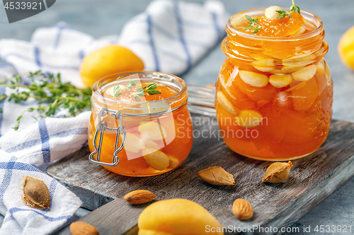 Image of Apricot homemade jam with almonds in glass jars.
