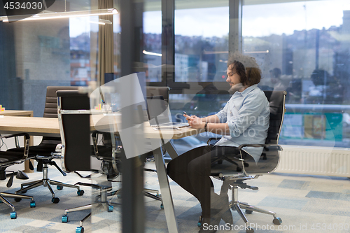 Image of Young casual businessman using smartphone