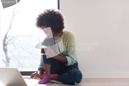 Image of black woman in the living room on the floor