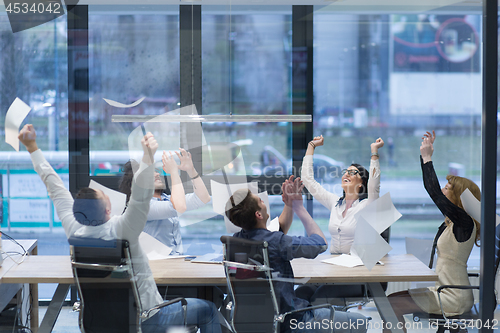 Image of startup Group of young business people throwing documents