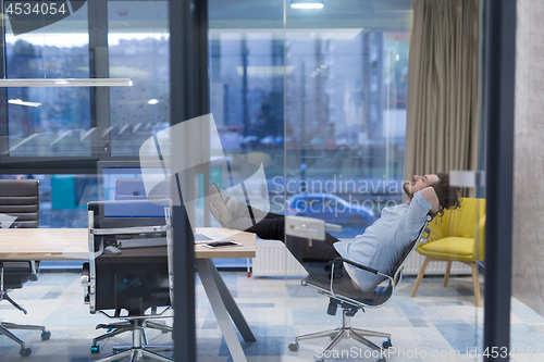 Image of young businessman relaxing at the desk