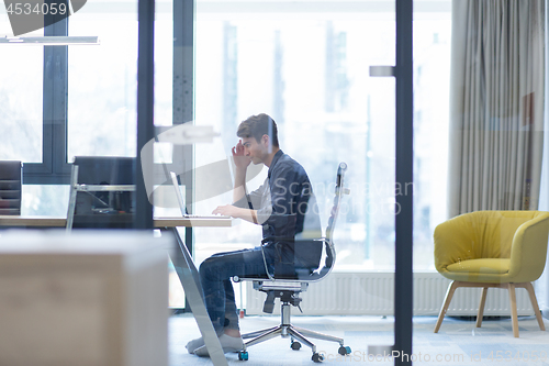 Image of businessman working using a laptop in startup office