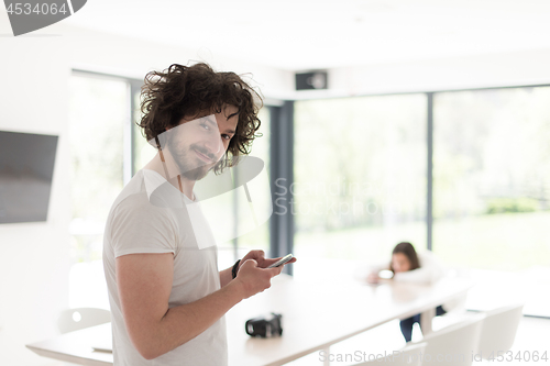 Image of young man using a mobile phone  at home