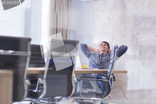 Image of young businessman relaxing at the desk