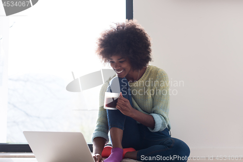 Image of black woman in the living room on the floor