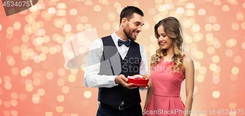 Image of happy couple with chocolate box in shape of heart