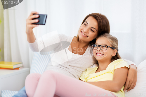 Image of happy family taking selfie by smartphone at home