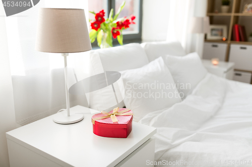 Image of gift in shape of heart on bedside table in bedroom