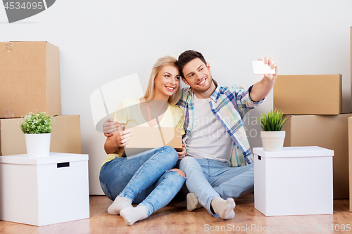 Image of couple taking selfie and moving to new home