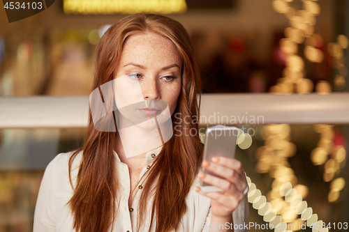 Image of woman with smartphone at restaurant
