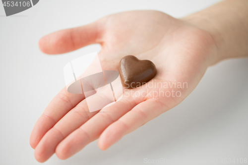 Image of close up of hand with heart shaped chocolate candy