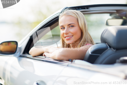 Image of happy young woman in convertible car