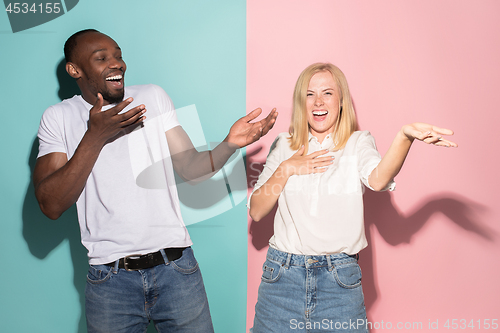 Image of happy afro man and woman. Dynamic image of caucasian female and afro male model on pink studio.
