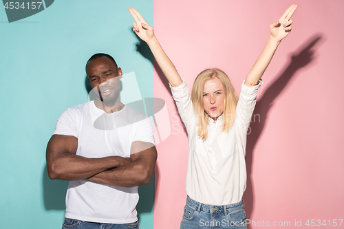 Image of We won. Winning success happy afro man and woman celebrating being a winner. Dynamic image of caucasian female and male model on pink studio.