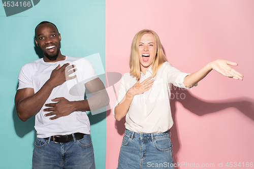 Image of happy afro man and woman. Dynamic image of caucasian female and afro male model on pink studio.