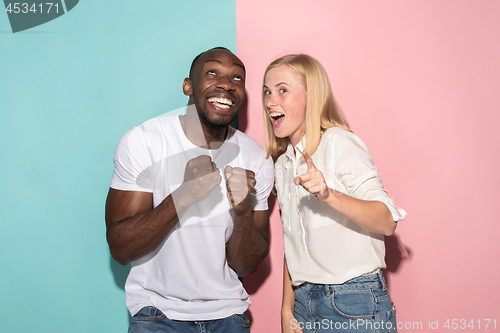 Image of happy afro man and woman. Dynamic image of caucasian female and afro male model on pink studio.