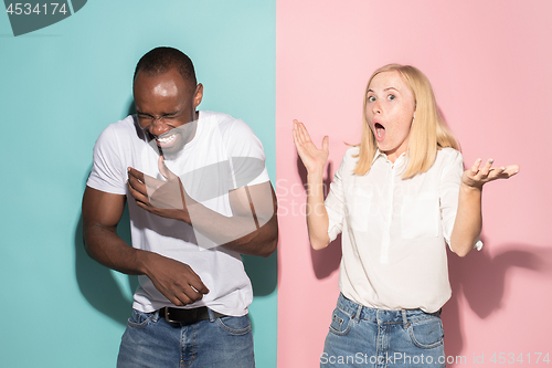 Image of happy afro man and woman. Dynamic image of caucasian female and afro male model on pink studio.