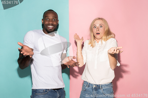 Image of happy afro man and woman. Dynamic image of caucasian female and afro male model on pink studio.