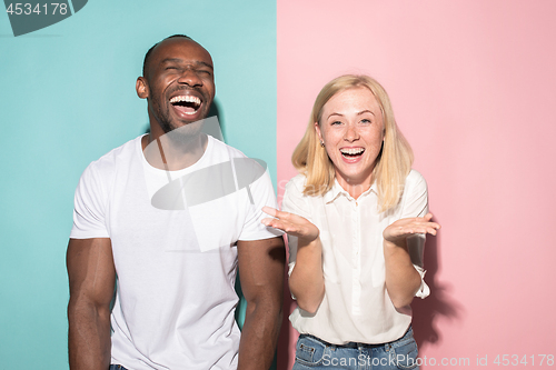 Image of happy afro man and woman. Dynamic image of caucasian female and afro male model on pink studio.