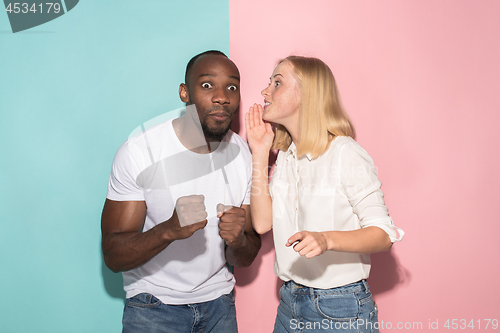 Image of happy afro man and woman. Dynamic image of caucasian female and afro male model on pink studio.