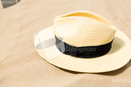 Image of straw hat on beach sand