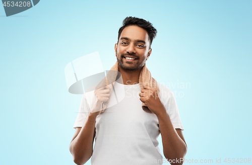 Image of smiling indian man with towel over grey background