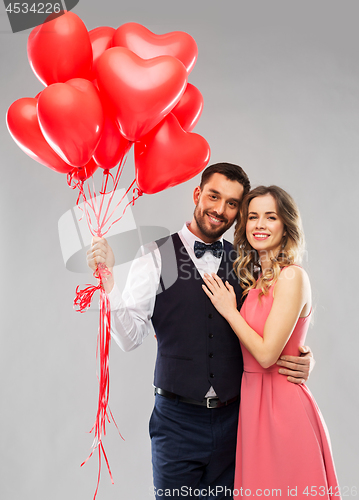 Image of happy couple with red heart shaped balloons