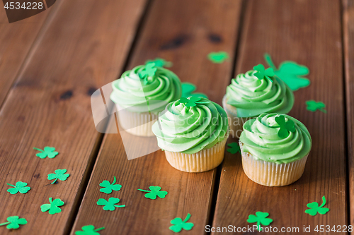 Image of green cupcakes and shamrock on wooden table