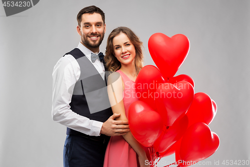 Image of happy couple with red heart shaped balloons