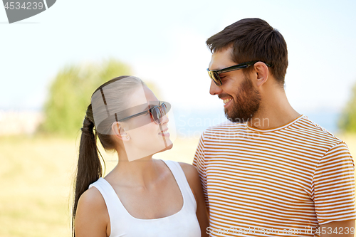 Image of happy couple in sunglasses outdoors in summer