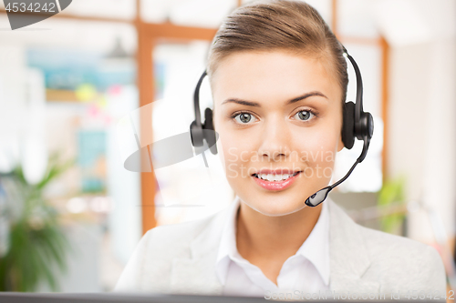 Image of helpline operator in headset working at office