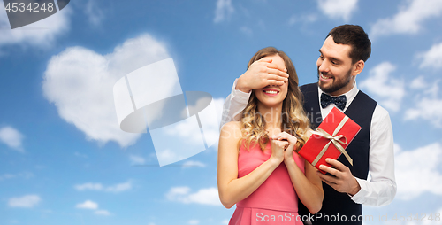 Image of happy man giving woman surprise present