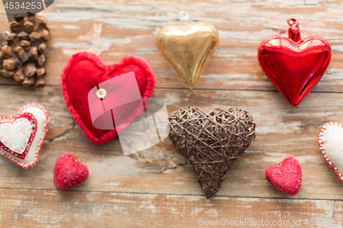 Image of heart shaped decorations on wooden background