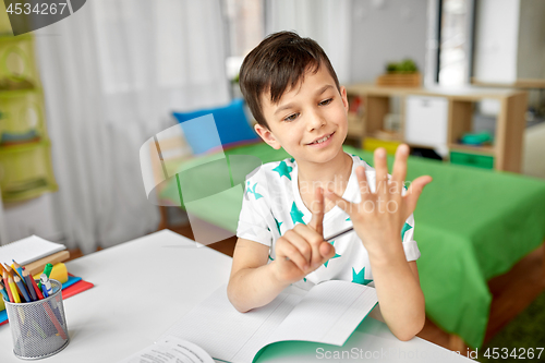 Image of boy doing homework and counting using fingers