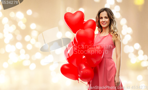 Image of happy young woman with red heart shaped balloons