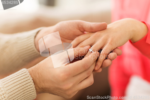 Image of man giving diamond ring to woman on valentines day