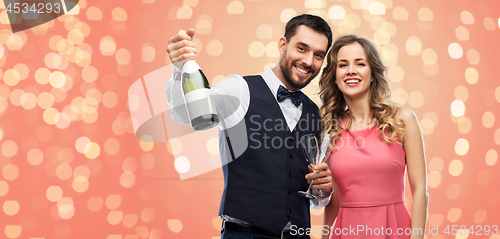 Image of happy couple with bottle of champagne and glasses