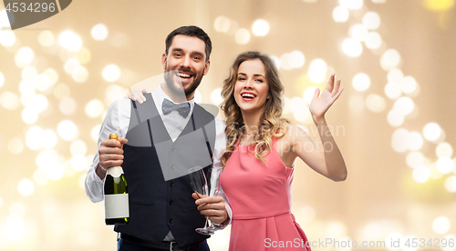 Image of happy couple with bottle of champagne and glasses