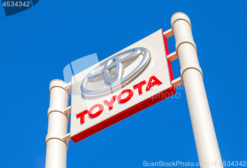 Image of Toyota automobile dealership sign against the blue sky backgroun