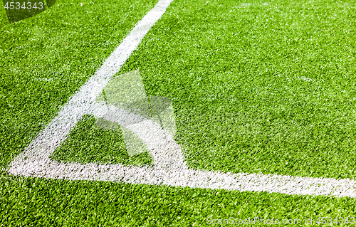 Image of White lines marking on green grass in the corner of the soccer o