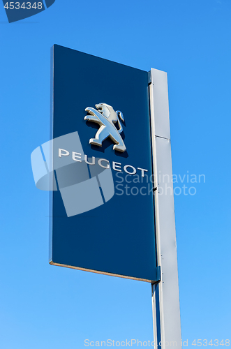 Image of Official dealership sign of Peugeot against the blue sky backgro