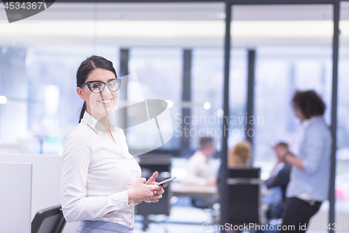 Image of Elegant Woman Using Mobile Phone in startup office building