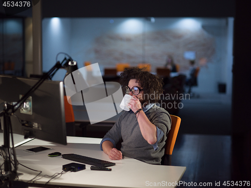 Image of man working on computer in dark startup office