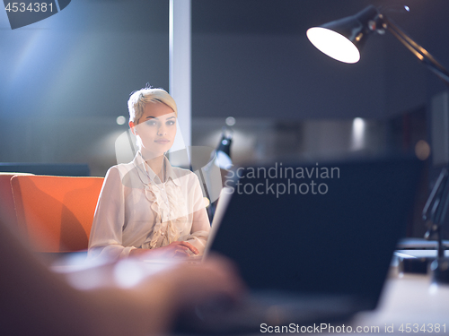 Image of woman working on laptop in night startup office