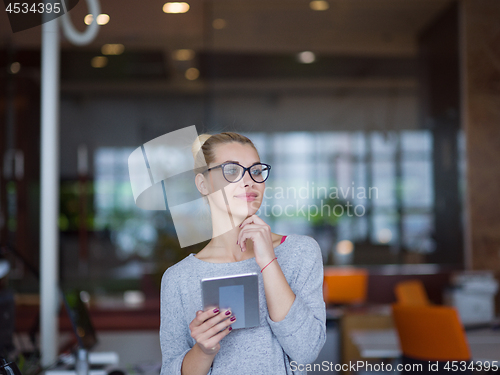 Image of woman working on digital tablet in night office