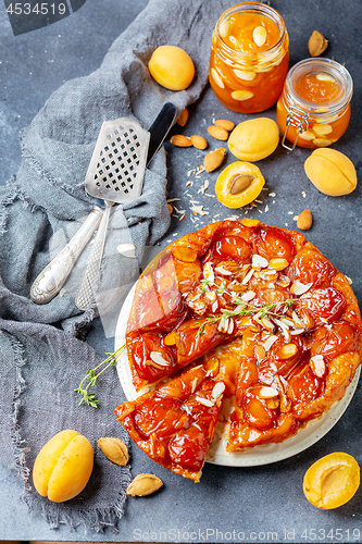 Image of Sliced caramelized tarte tatin pie with apricots.