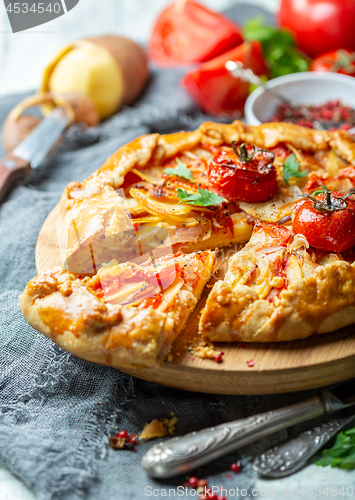 Image of Piece of cake with potatoes, bacon and tomatoes.